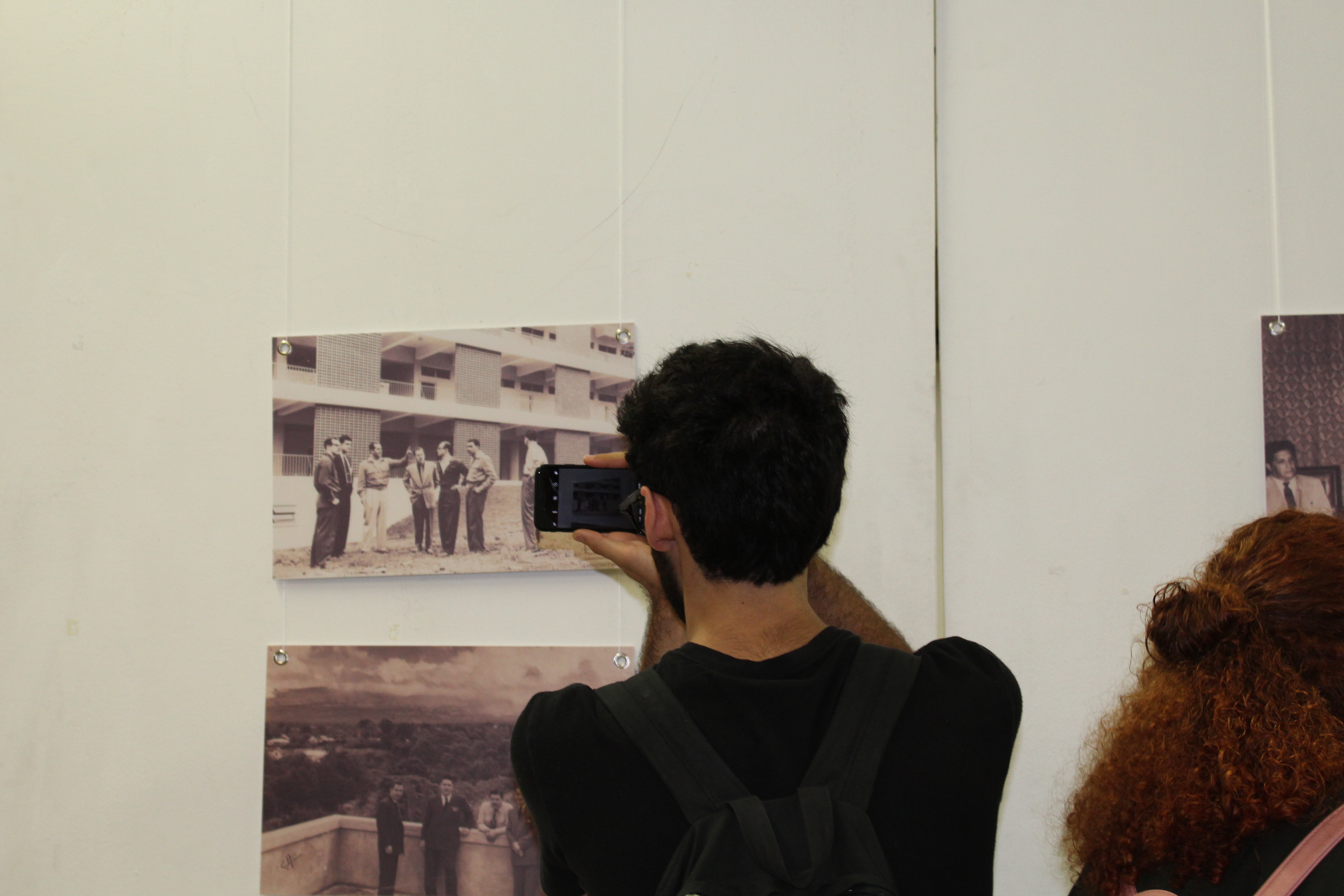 img-galeria-quote-Estudiantes de la UCR asistieron a la inauguración de la Exposición fotográfica: 45 años de la VAS. Este joven observa y le toma una foto a una fotografía del Edificio de la Escuela de Estudios Generales.