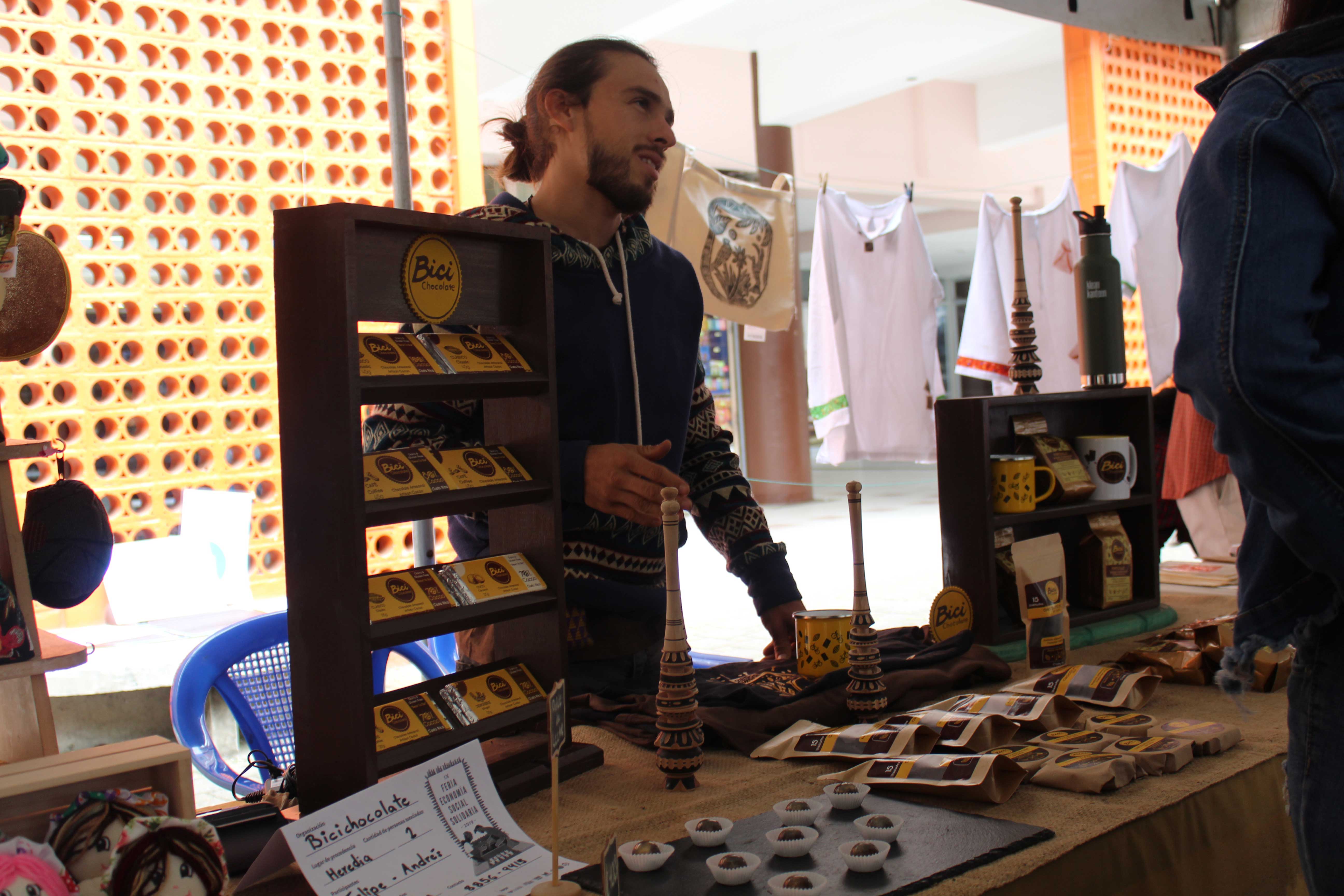 img-galeria-quote-Hombre ofrece sus productos a base de chocolate y ofrece algunas muestras gratis en su mesa. 
