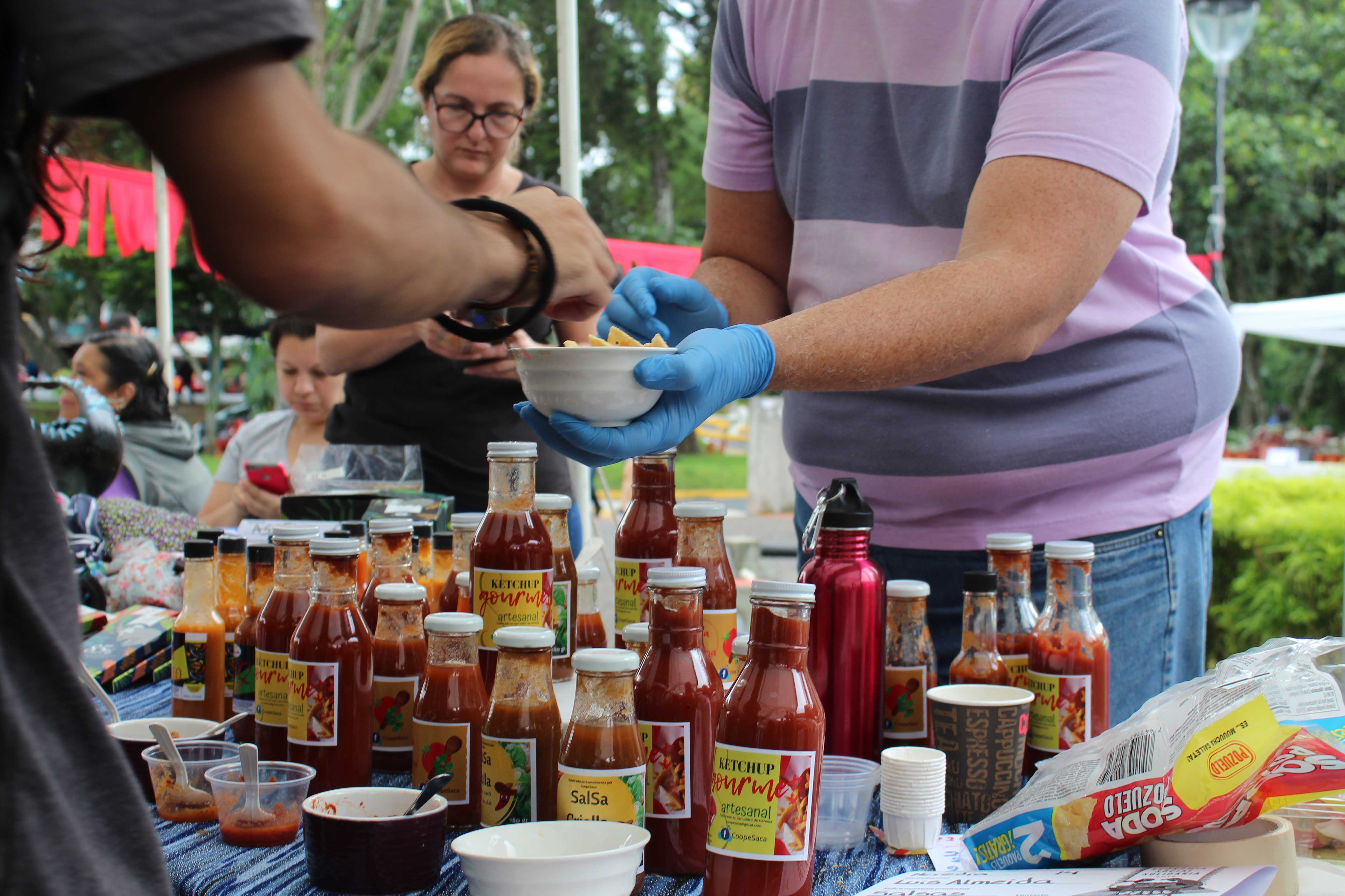 img-galeria-quote-Vendedor regala una muestra gratis de sus salsas picantes a joven interesado en el producto.