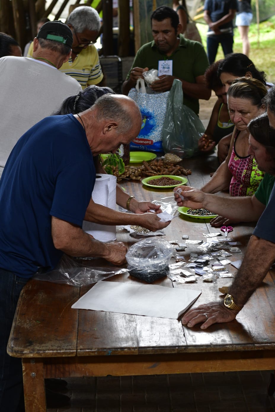 img-galeria-quote-Serie de personas en una mesa intercambiando semillas durante el Festival del Agua.
