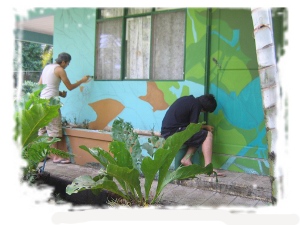 Estudiantes del TCU pintando murales en escuelas. 